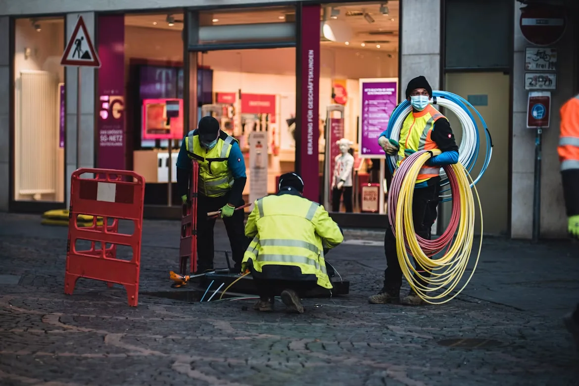 Street installation team carrying coils of cable